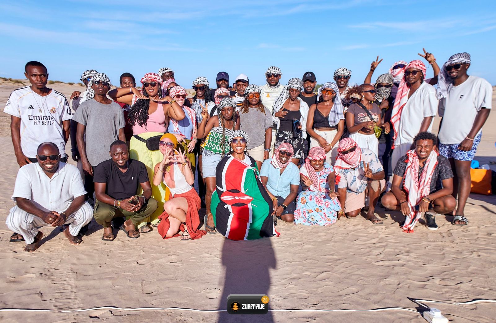 The 2026 residents gathered on a beach in Kilifi, smiling and waving, some holding a Kenyan flag.