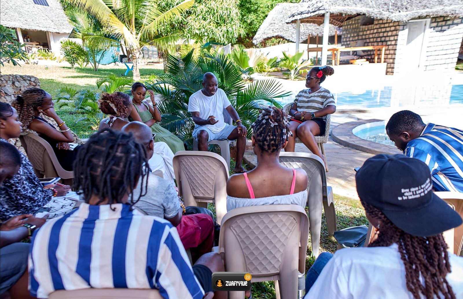 Residents sitting in a wide circle in a sunny garden, deep in conversation.